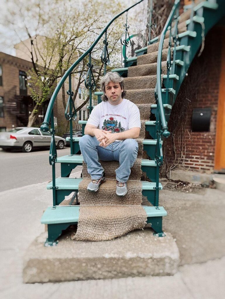Len O’Neill seated on outdoor steps